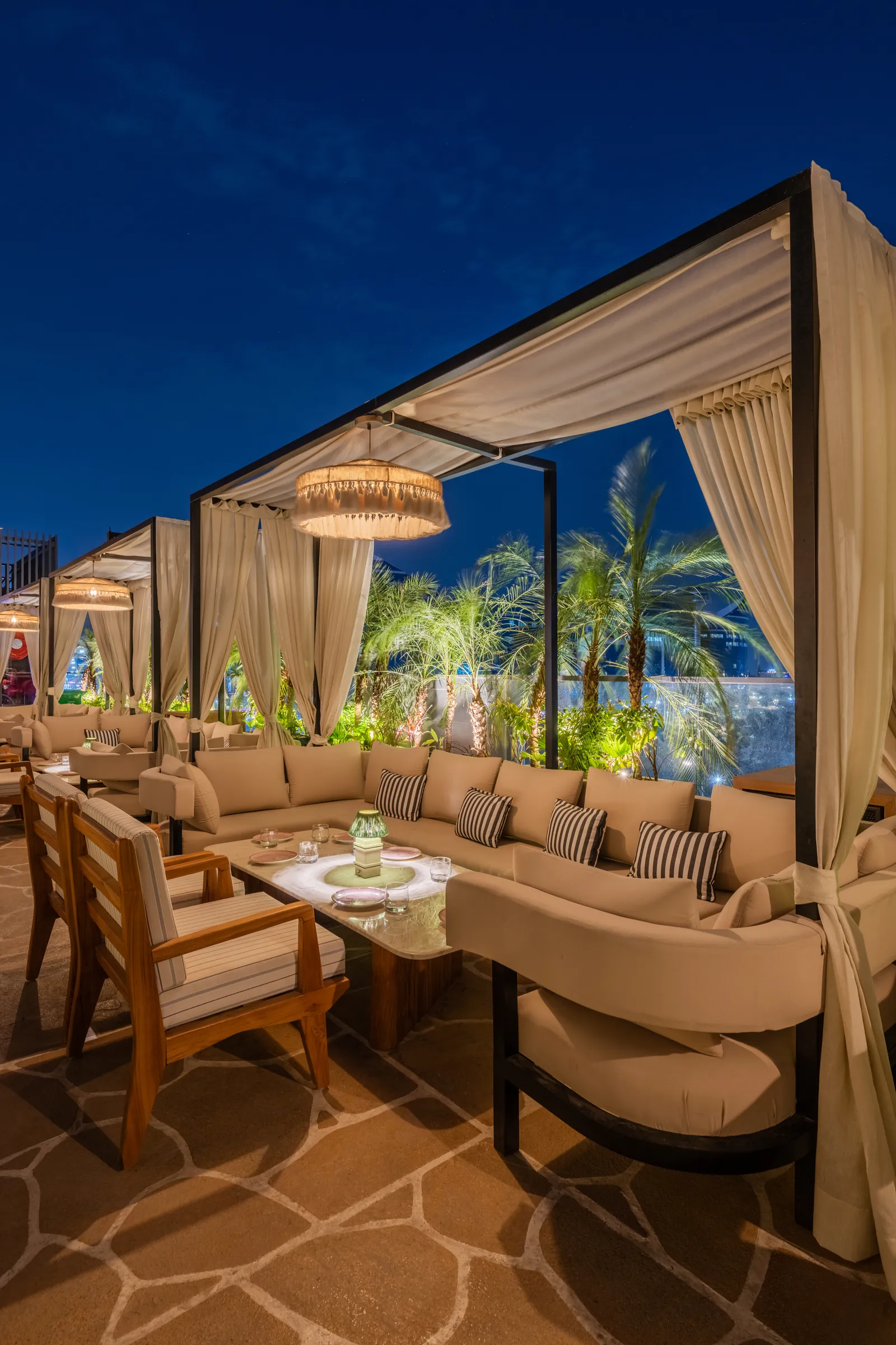 A curtained cabana on the terrace at night