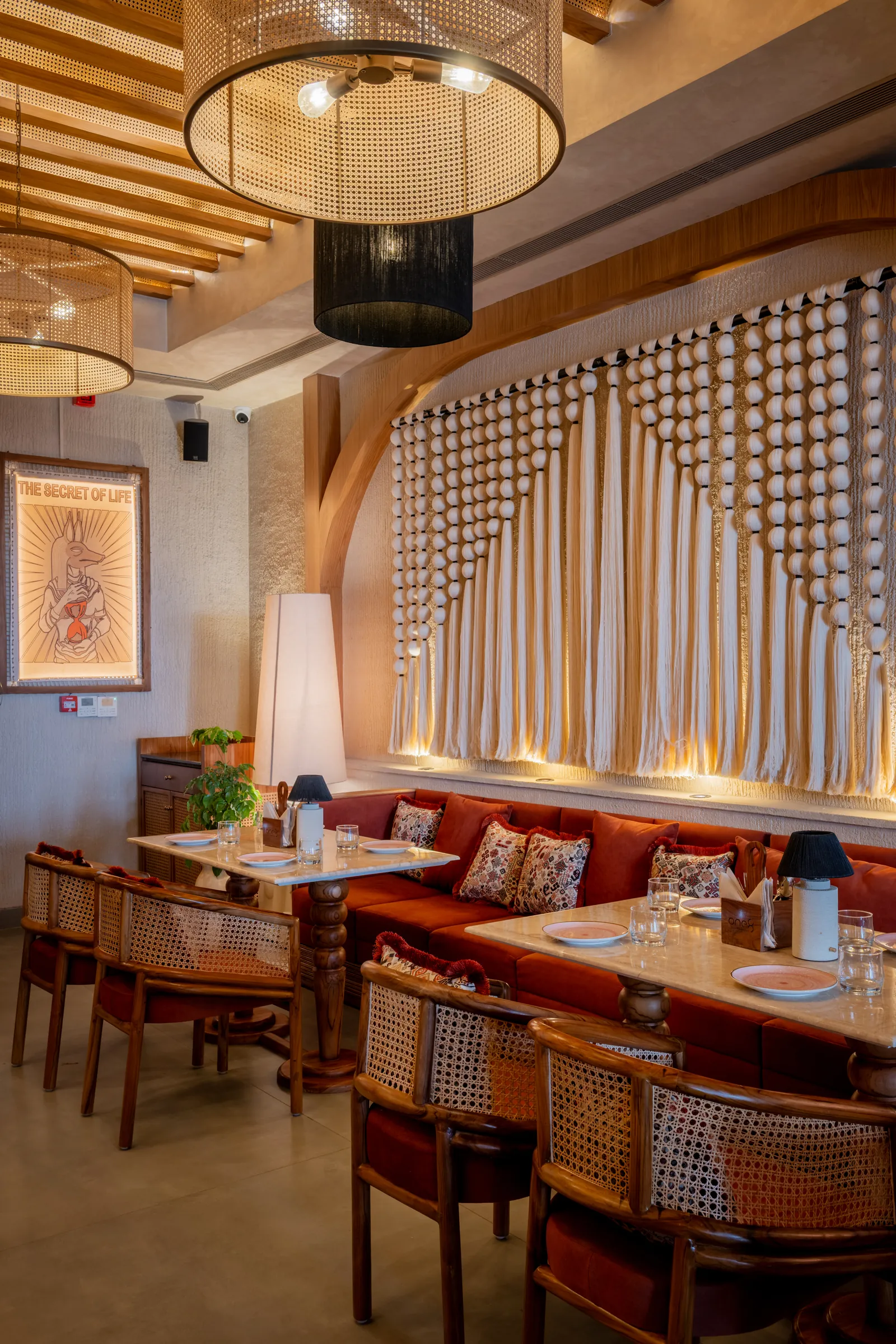 A macramé wall behind the banquette