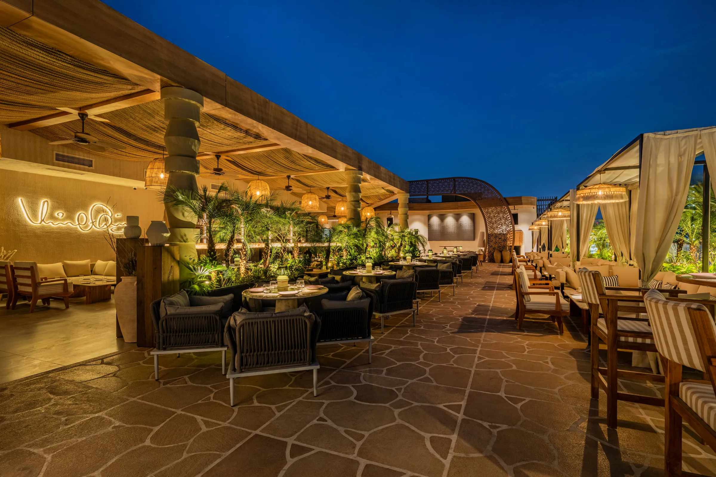 The terrace at night, the neon signature glowing at the far end