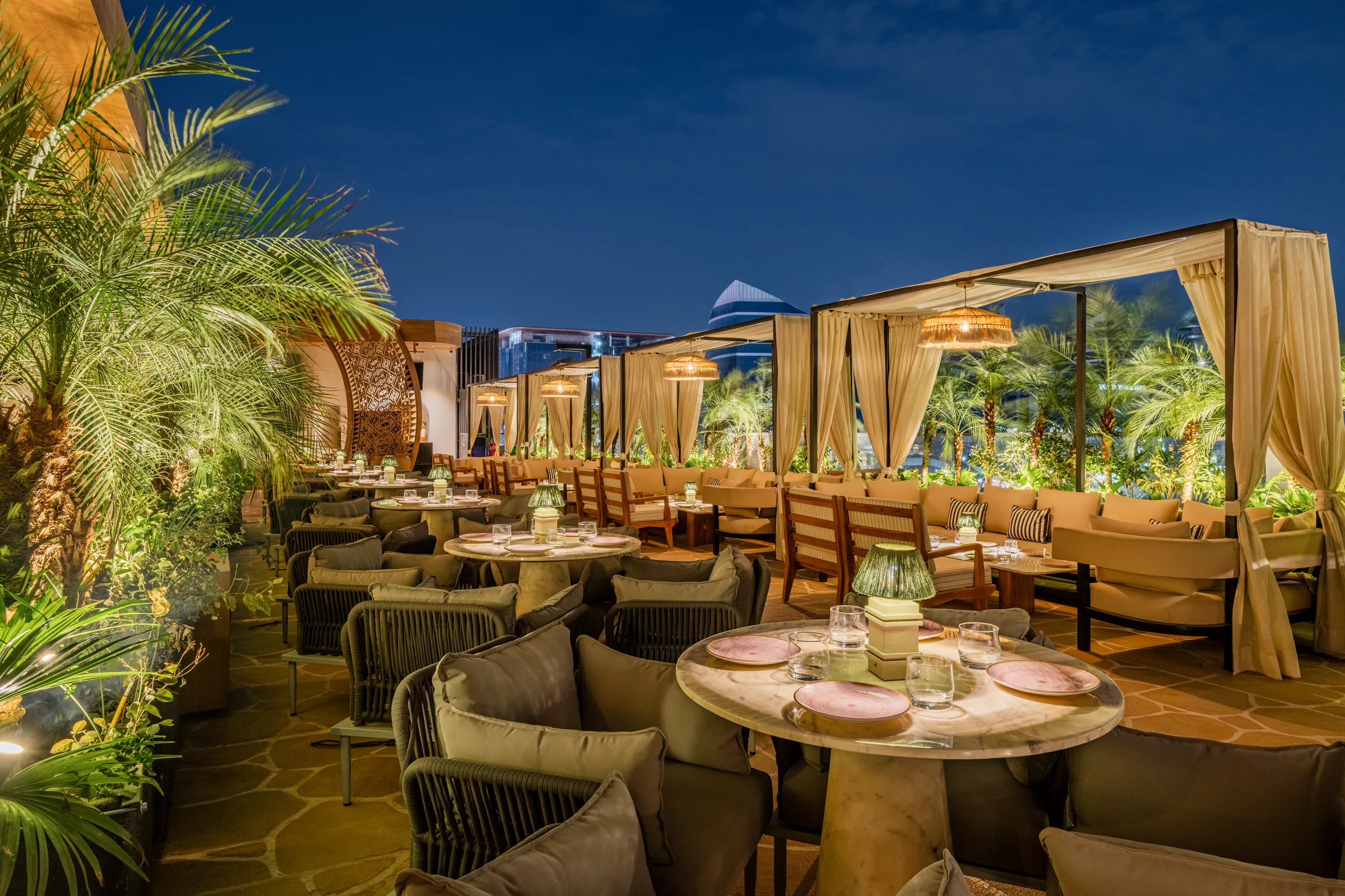 Terrace tables between palms at night