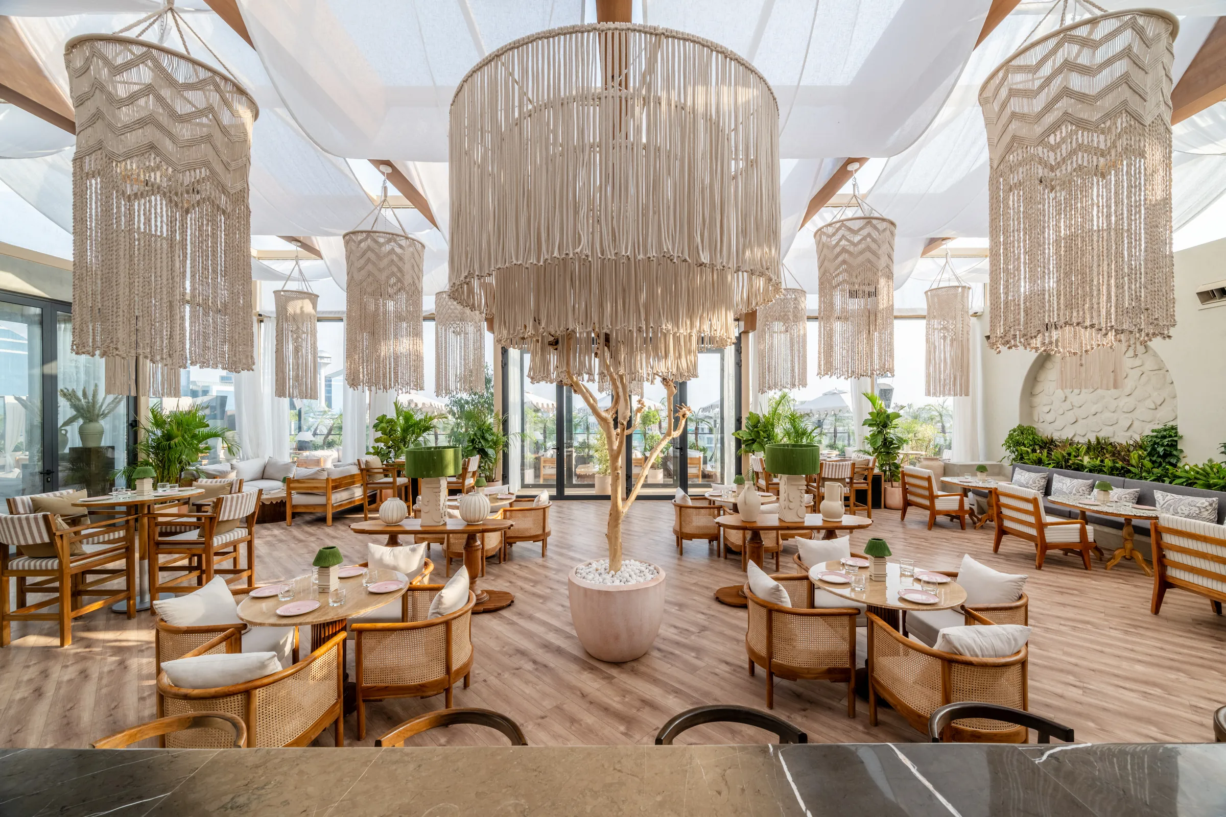 Macramé chandeliers under the white sails of the glasshouse
